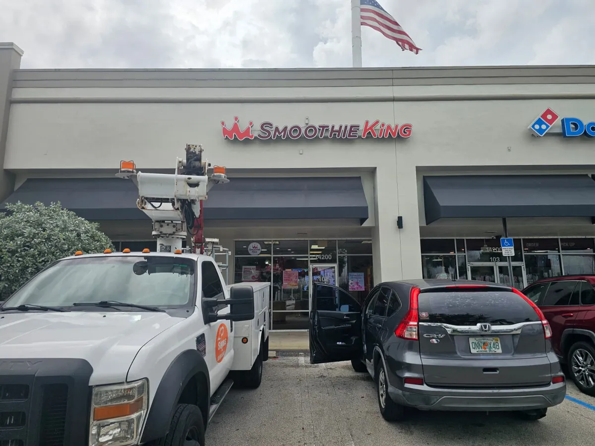 Smoothie King storefront sign installed by Spazio Design bucket truck in Miami